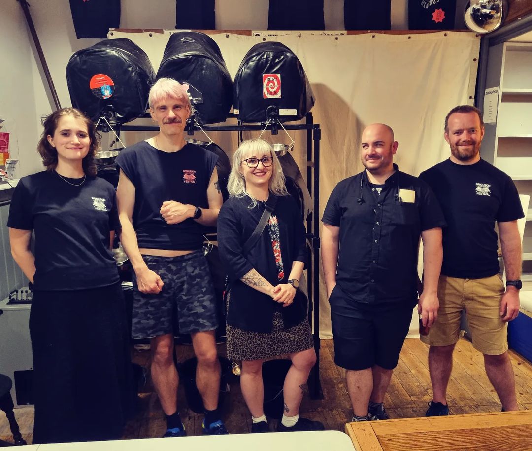 people standing in front of beer casks