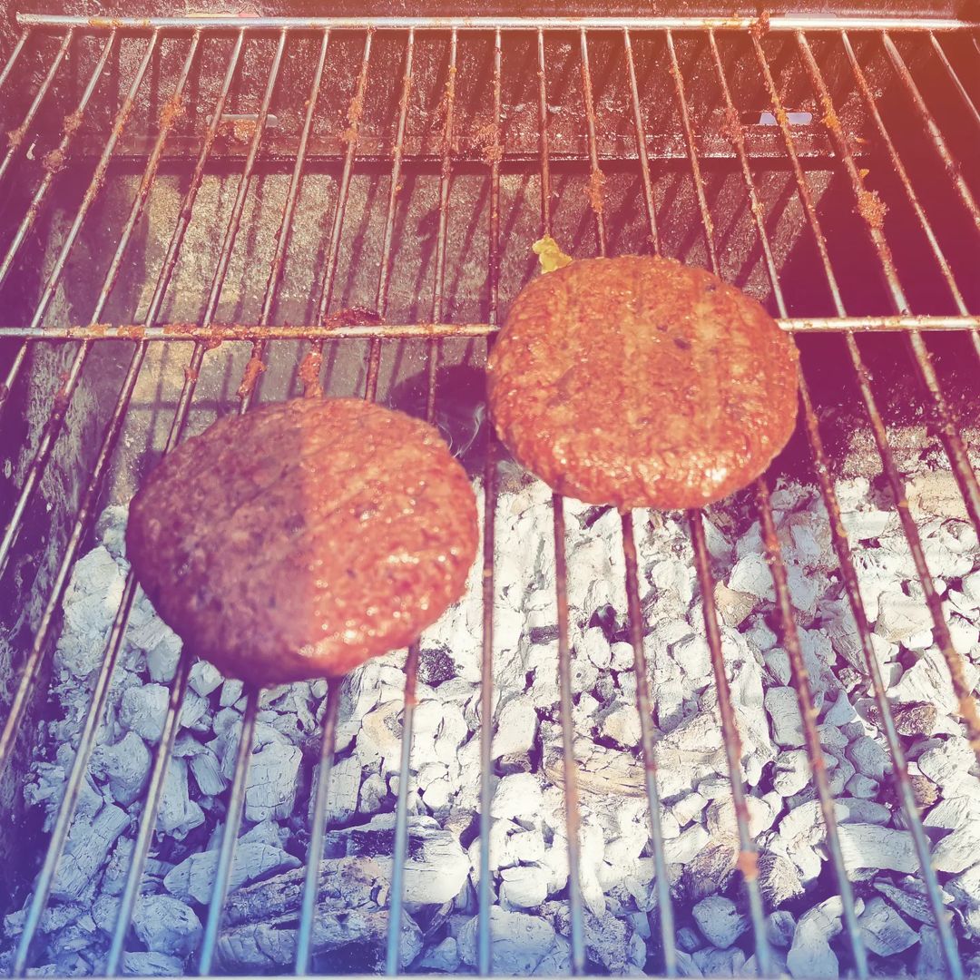 vegan burgers cooking on a barbecue